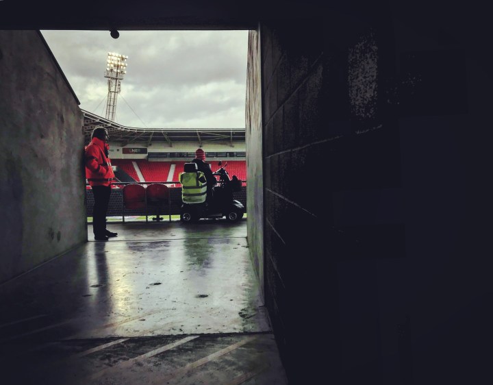 A steward and a Doncaster Rovers supporter watch the rain fall at the Keepmoat Stadium during half-time in Rovers' 4-0 home defeat to Fleetwood Town