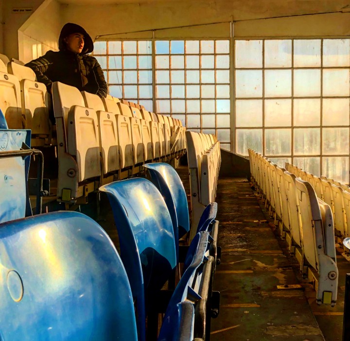 A supporter watches a match from the grandstand at Maurice Rebak Stadium