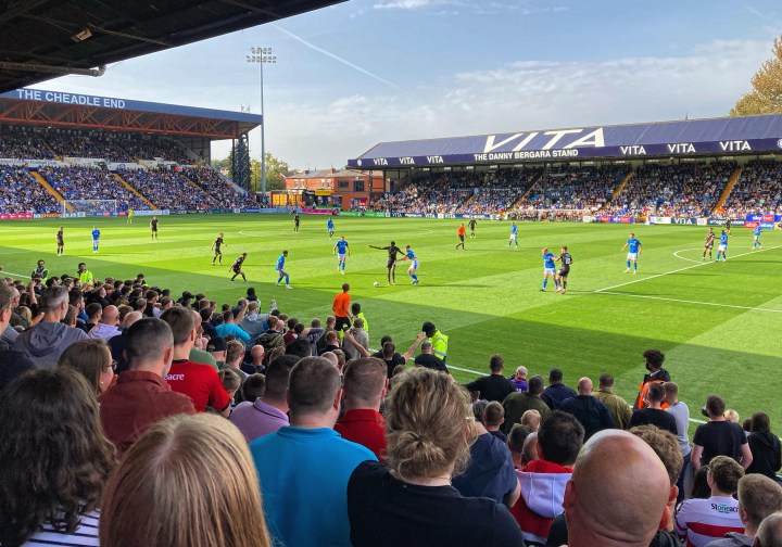 Stockport County play Doncaster Rovers in front of a large crowd at Edgeley Park as seen from among the Rovers supporters