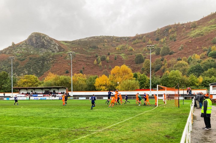 The hills behind Conwy Borough's ground are full of autumnal colours as Borough and Llannefydd players challenge for a corner