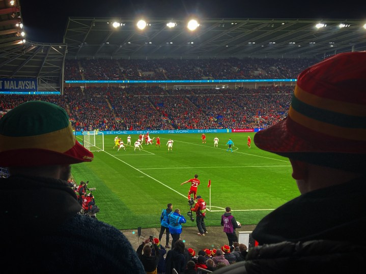 Daniel James takes a corner for Wales in their home match with Turkey, seen between the bucket hats of two Wales fans
