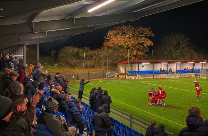 Colwyn Bay players and supporters celebrate a goal against Connah's Quay Nomads during a night match at Llanelian Road