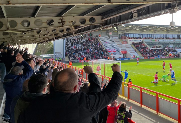 Doncaster Rovers fans celebrate a goal by Luke Molyneux, who is points to them from the field, during Rovers 3-0 win at Morecambe