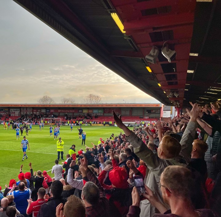 Doncaster Rovers fans celebrate and cheer their team's players at Crewe Alexandra's Gresty Road following their first leg play-off semi-final win