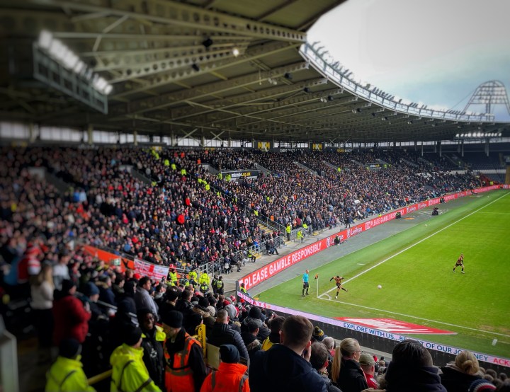 A Hull City player takes a corner against Doncaster Rovers in front of a packed away end
