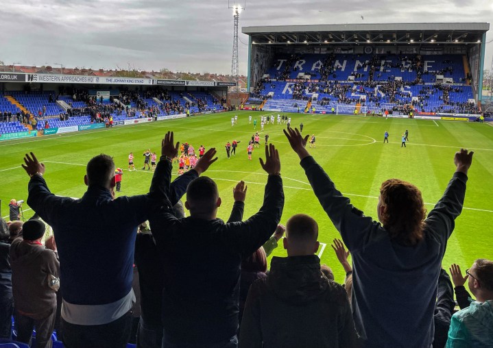 Doncaster fans in the stands celebrate following their team's 3-0 win at Tranmere as the players on the pitch applaud them