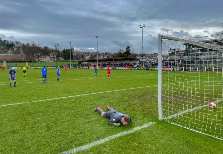 The Llanuwchllyn goalkeeper lies face down whilst a defender sinks to his knees following a Denbigh Town goal