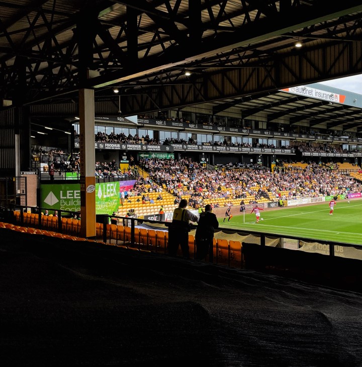 Two stewards watch Doncaster Rovers take a corner kick during the away win at Port Vale.